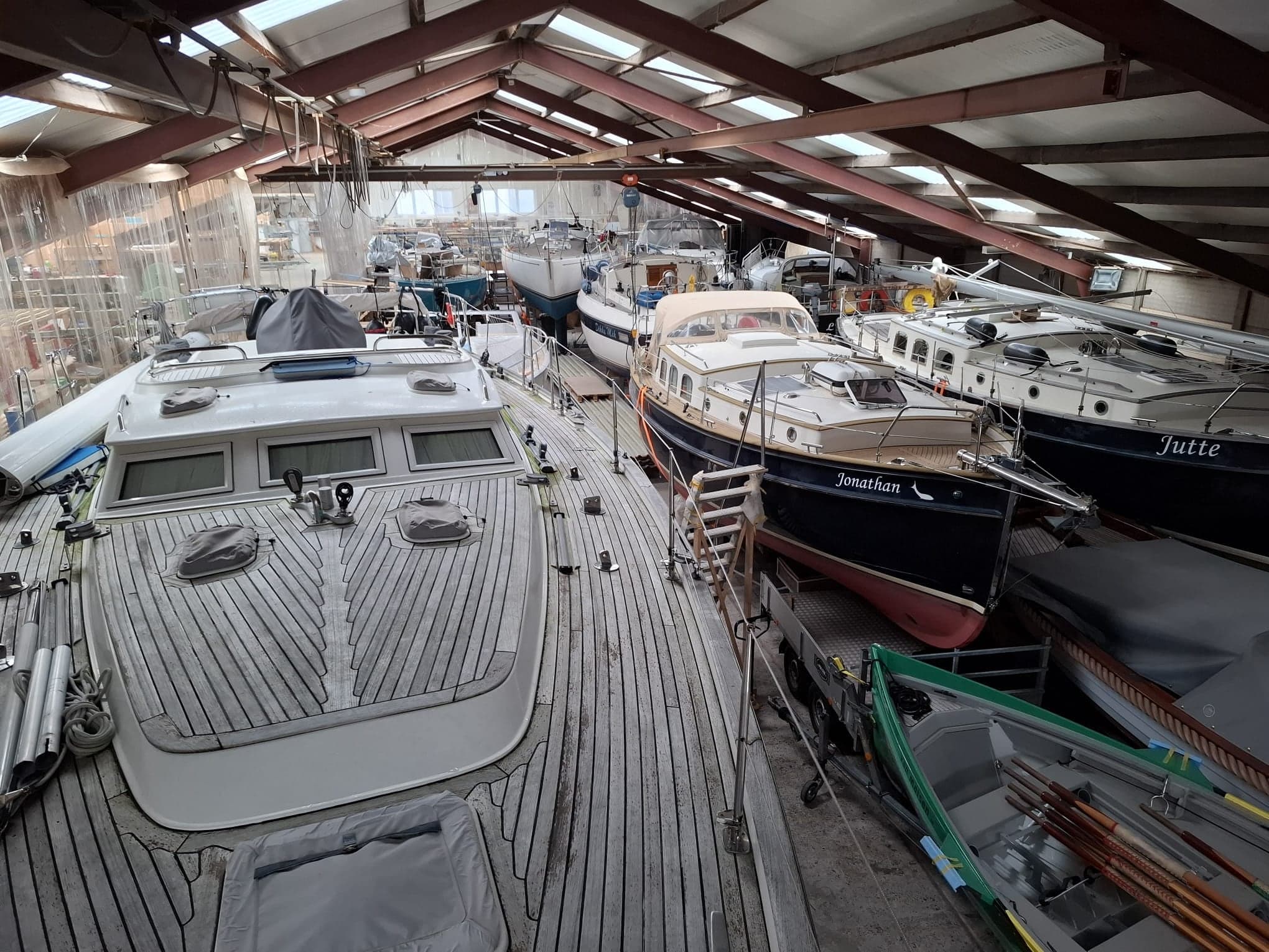 De werfhal met jachten en een roeiboot in aanbouw en onderhoud